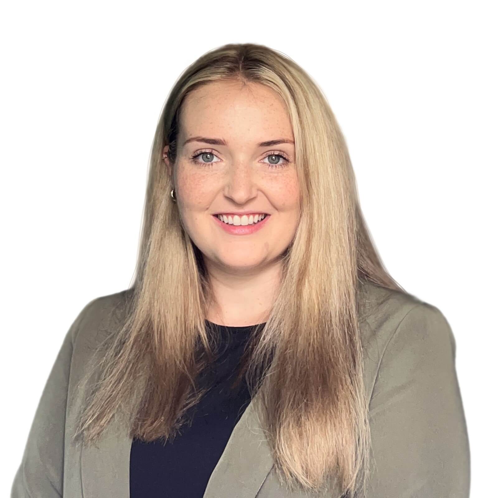 A woman with long blonde hair is wearing a dark top and light blazer, smiling at the camera against a white background