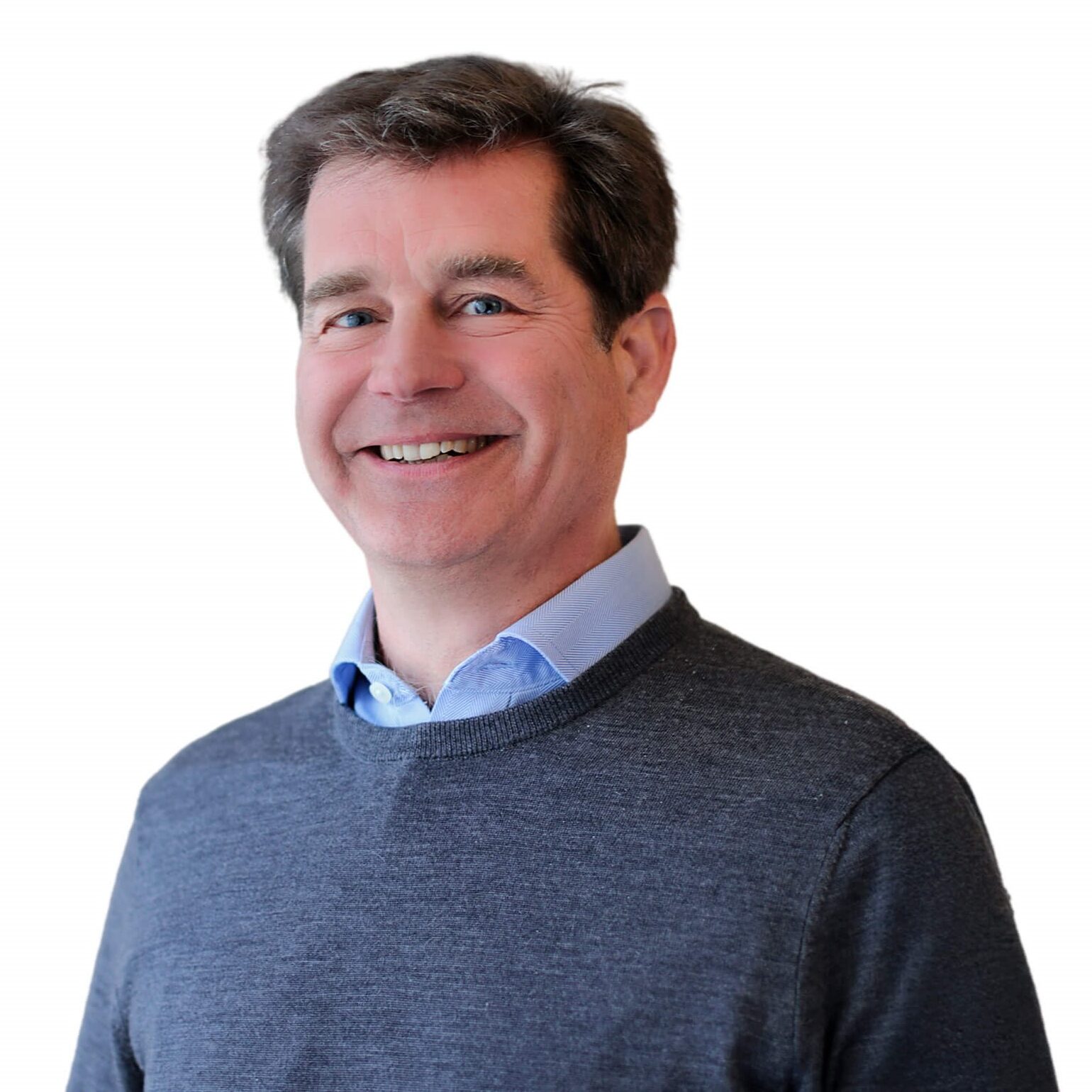 A smiling man wearing a sweater poses for the camera.